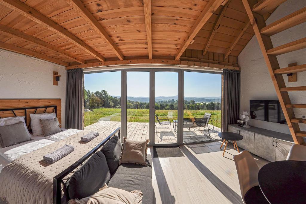 a bedroom with a bed and a large window at Widokowe Stodoły Bieszczady in Lesko