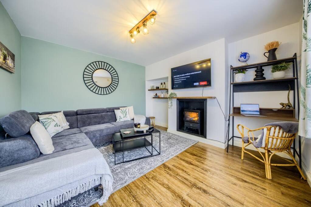 考文垂的住宿－LOW rate for a 4-Bedroom House in Coventry with Free Unlimited Wi-fi 2 Car Parking 53 QMC，带沙发和壁炉的客厅