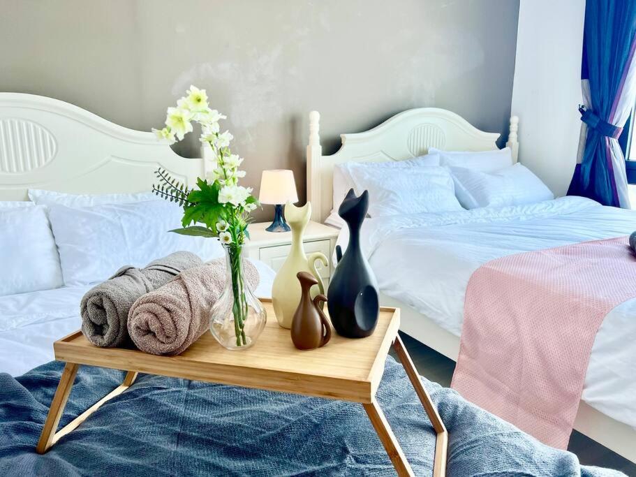 セティア・アラムにあるT3 1-10 Pax Trefoil 2Room Setia Alam Cozy Home WiFi TVのベッドルーム1室(ベッド2台、花のテーブル付)