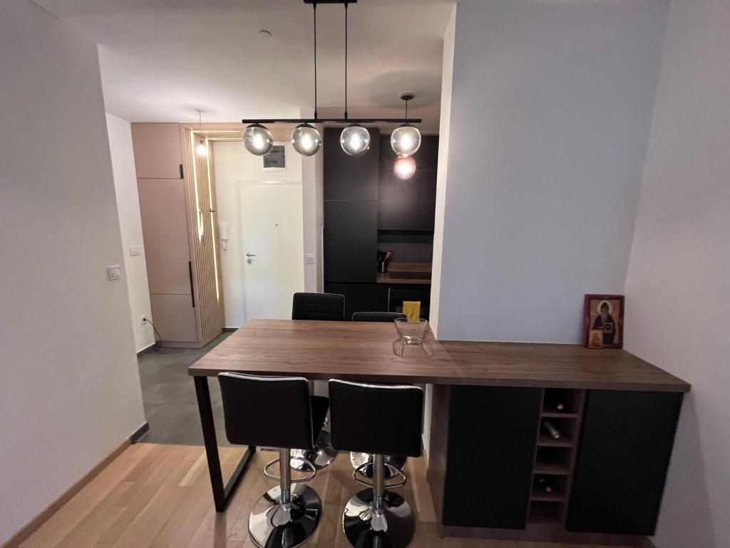 a dining room with a wooden table and black chairs at Apartman Madagaskar in Banja Luka