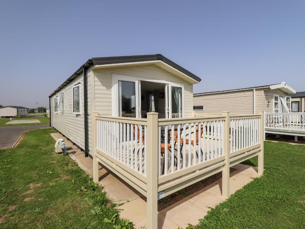 a tiny house with a porch and a deck at 62 Pinewood in Mablethorpe
