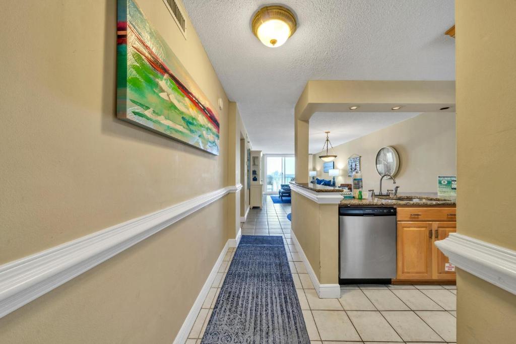 a hallway of a kitchen with a sink and a counter at Destin on the Gulf 403 - This is a beautiful beach front condo with a great view of the gulf in Destin