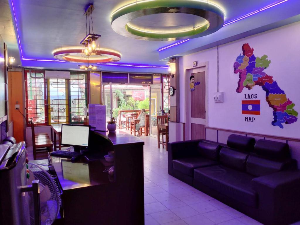 永珍的住宿－Rainbow Hotel Vientiane，客厅配有沙发和桌子