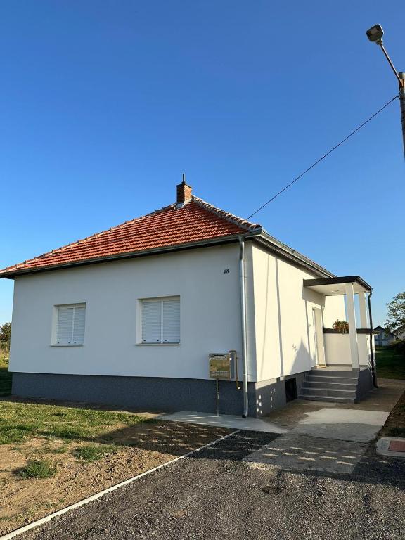 een wit huis met een rood dak bij Kuća za odmor Ruža in Nuštar