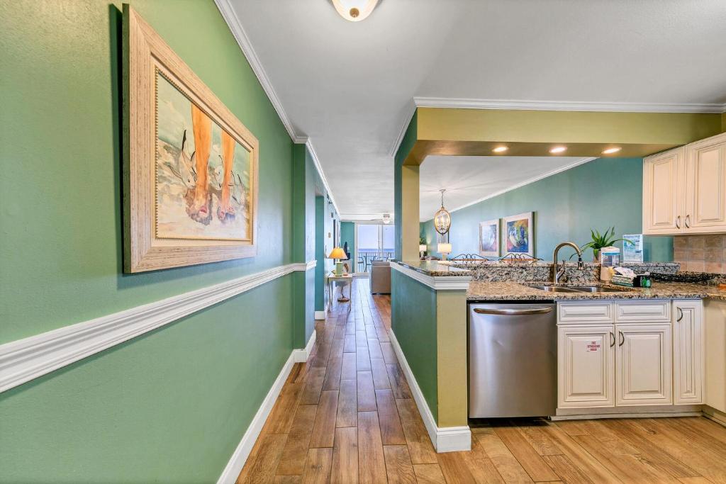 a kitchen with green walls and a counter top at Destin on the Gulf 702 - Directly on the beach seventh floor with the best views in Destin