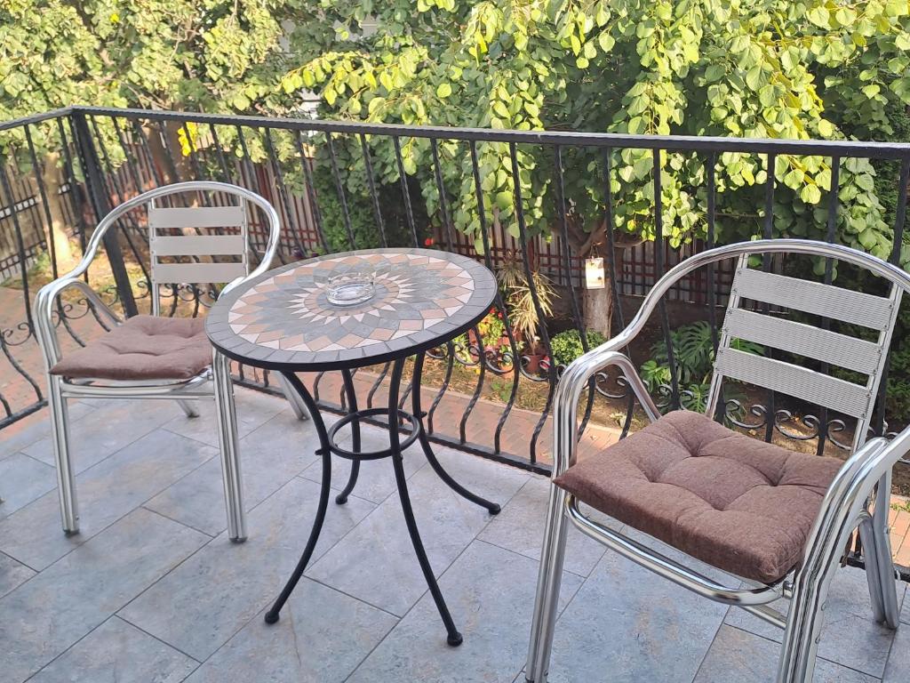 einen Terrassentisch und zwei Stühle sowie einen Tisch und Stühle in der Unterkunft Pensiunea Theo Enelid in Afumaţi