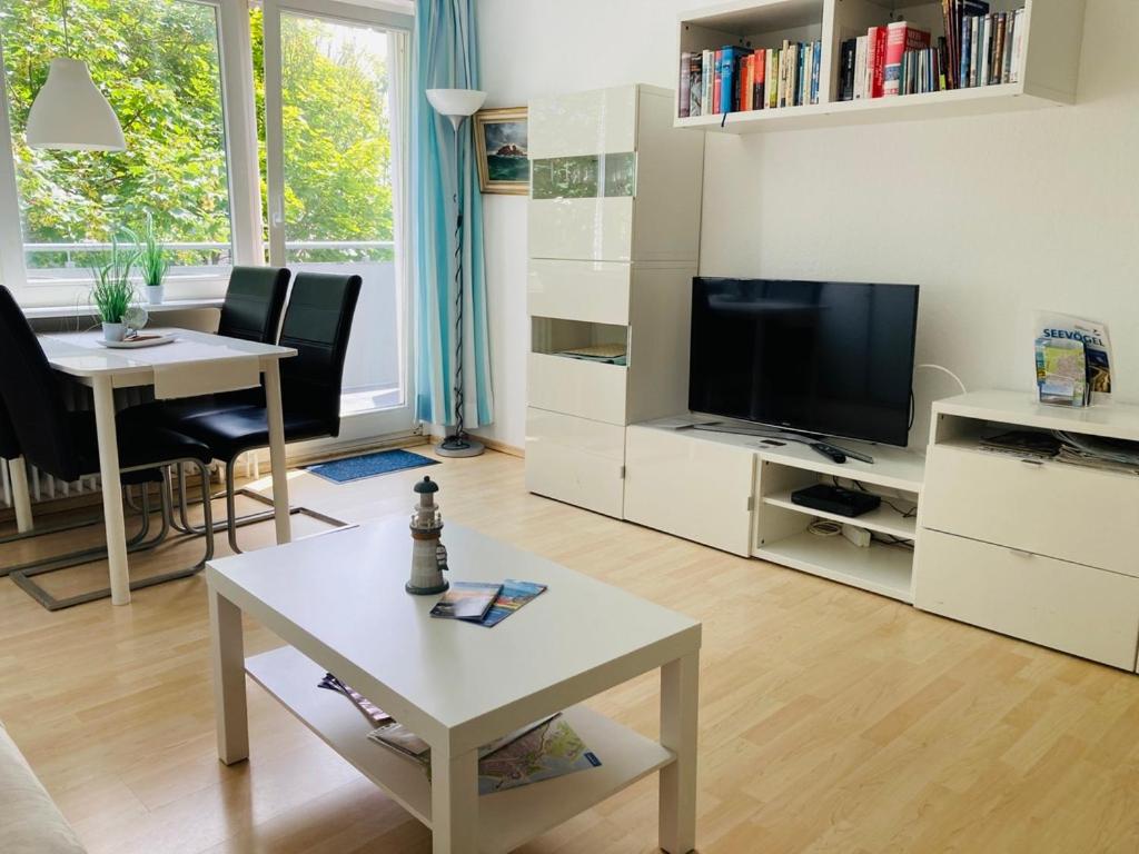 ein Wohnzimmer mit einem TV und einem Tisch in der Unterkunft Amerigo Vespucci in Helgoland