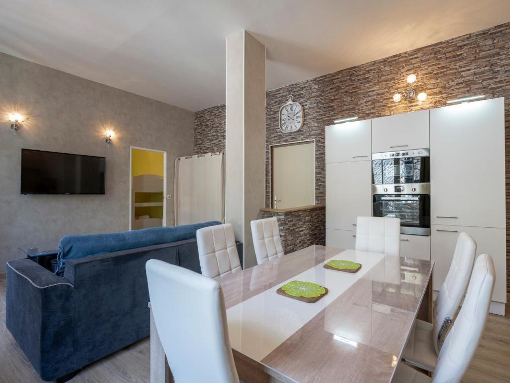 une salle à manger avec une table et un canapé bleu dans l'établissement Mont-Dore - Charmant T2 Bis en Centre avec WIFI, 6 pers - FR-1-608-33, à Le Mont-Dore