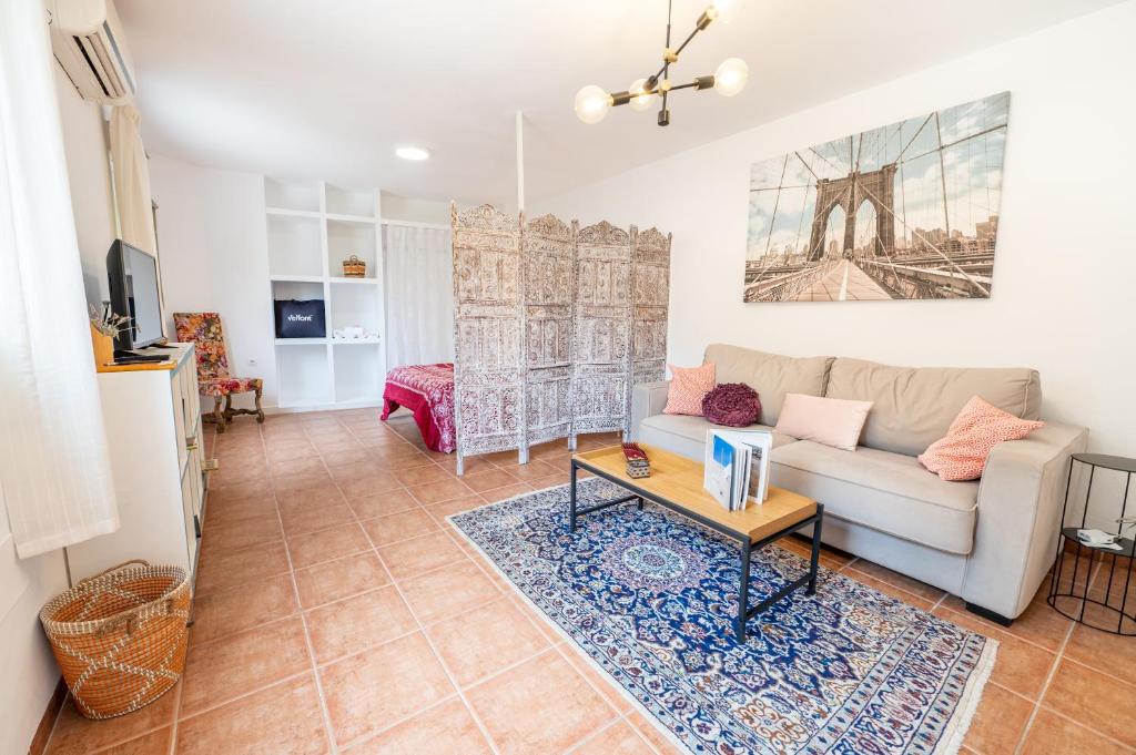 a living room with a couch and a table at Casa "La Gata Azul" con jardín privado in El Campillo del Moro