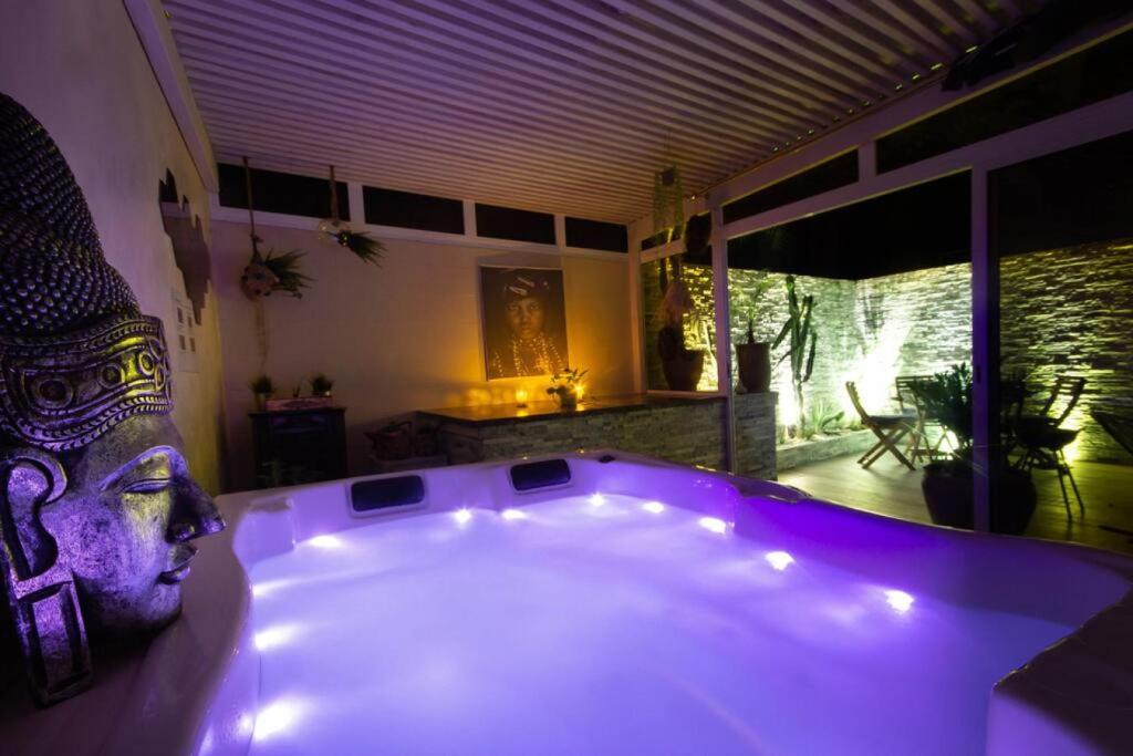 a large tub with a statue of a head in a room at Luxury Duplex - Private Jacuzzi - Center Hivernage in Marrakech