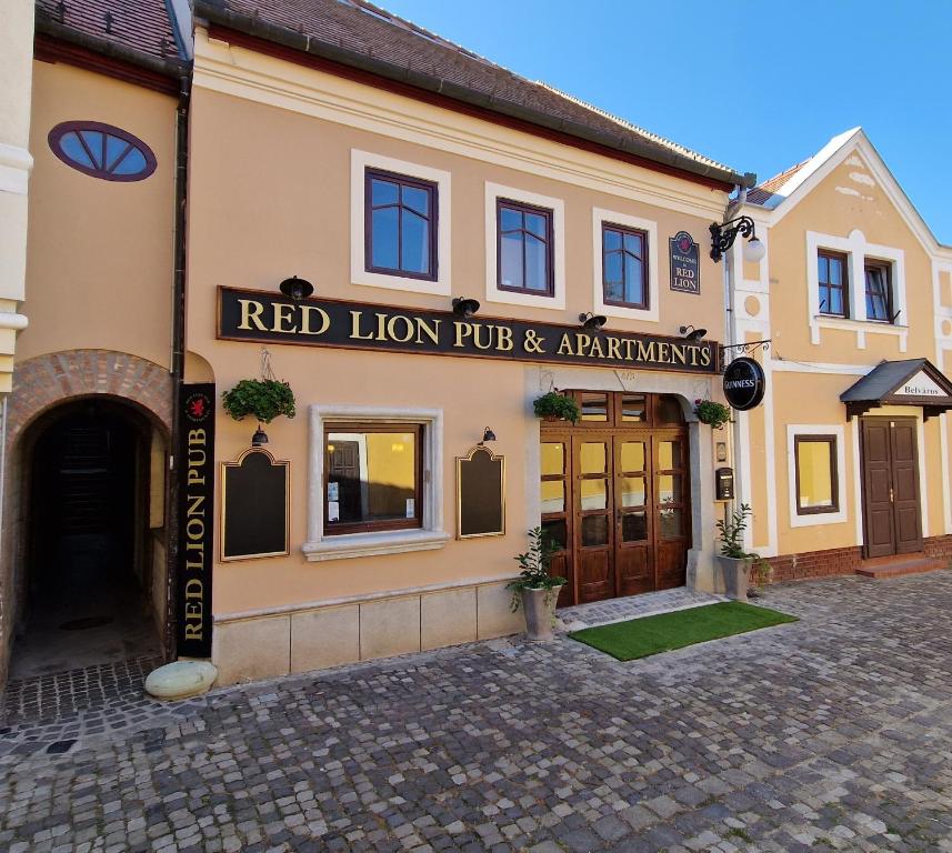 センテンドレにあるRed Lion Pub & Apartments Szentendreの赤獅子居酒屋とアパートメントのある建物