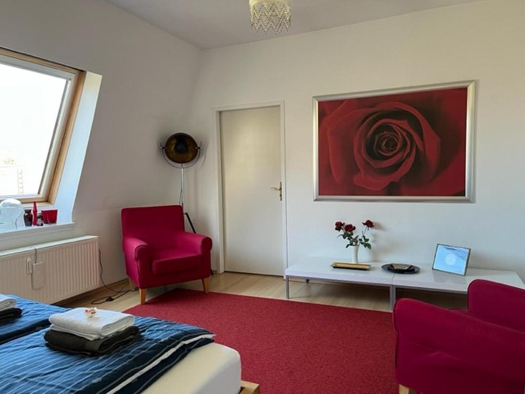Zimmer mit einem Bett, zwei Stühlen und einem Gemälde in der Unterkunft Exclusives Wohnen im Centrum Oldenburgs in Oldenburg