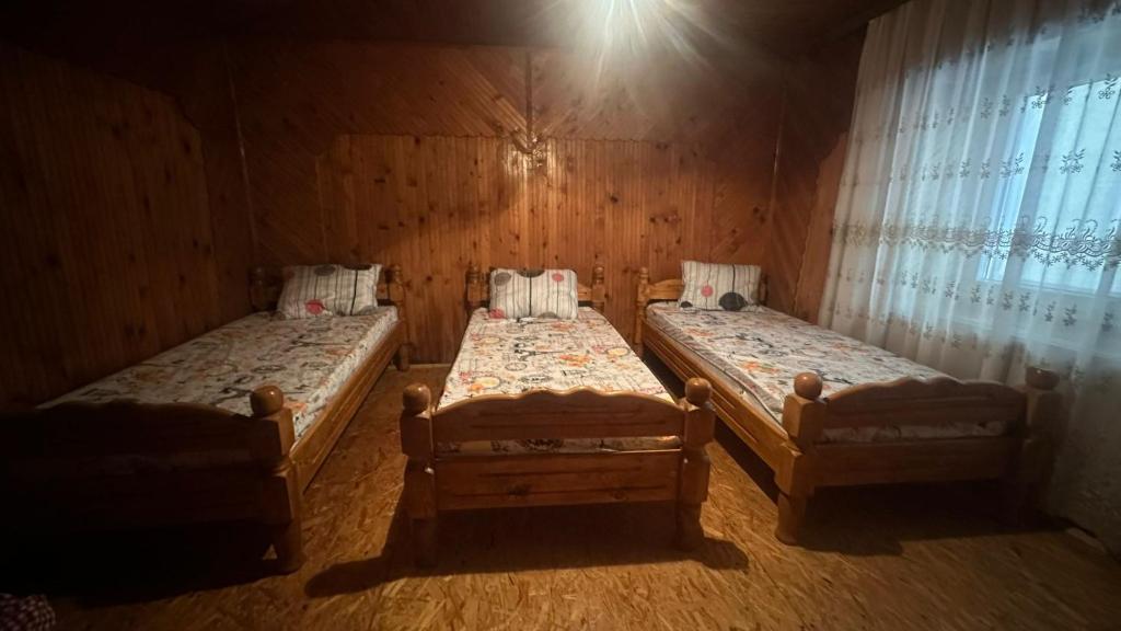 two twin beds in a room with a window at Guest House BOZVILL in Bozovec