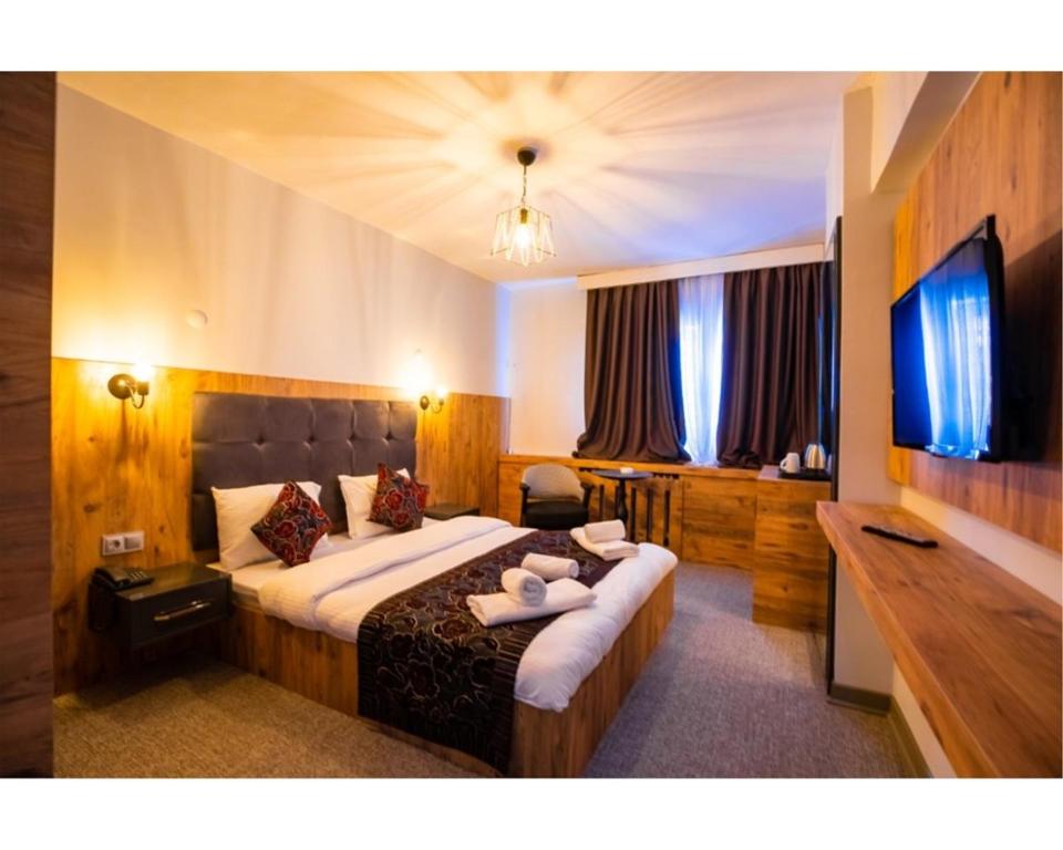 a hotel room with a large bed and a television at OTEL374 in Bolu