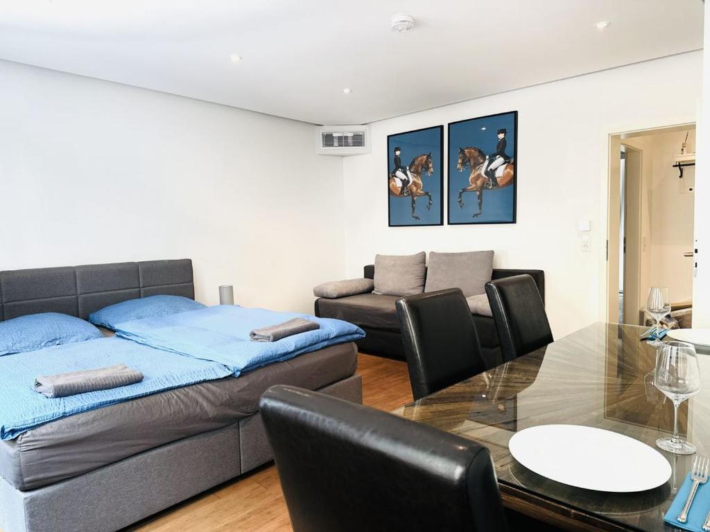 a living room with a bed and a table at City Center Apartments Düsseldorf in Düsseldorf