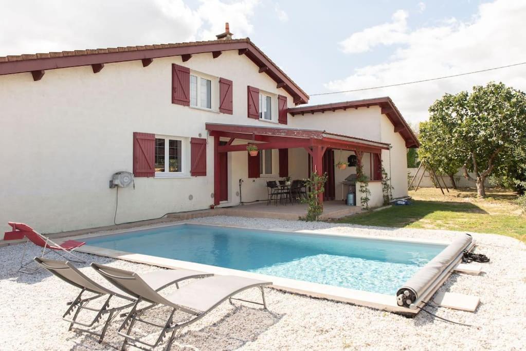 a villa with a swimming pool in front of a house at Villa Saint Loubès in Saint-Loubès