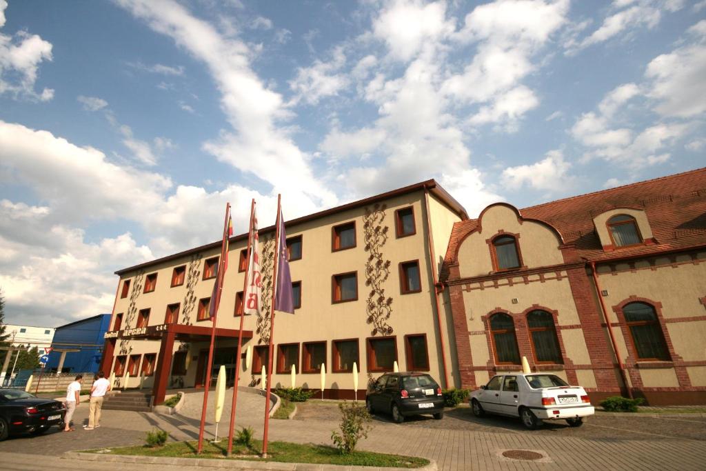 a large building with cars parked in a parking lot at Hotel Arena in Târgu-Mureş