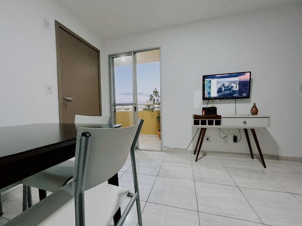 a living room with a dining table and a television at Repouso São Miguel in Brasilia