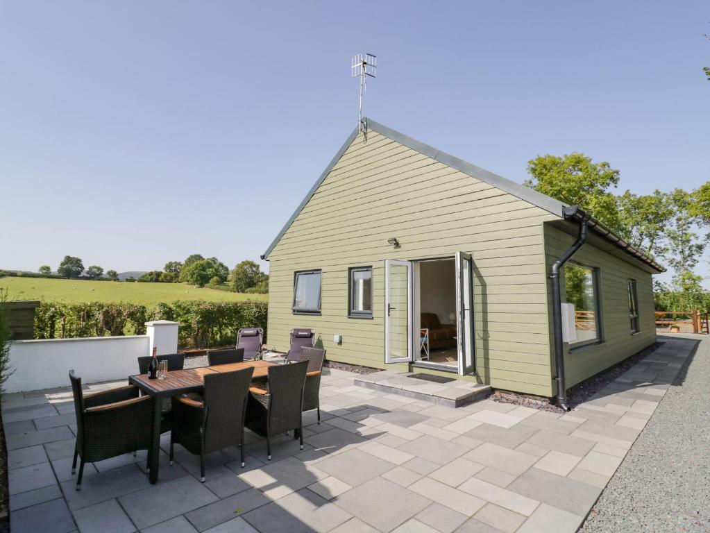 a small yellow building with a table and chairs at Southend in Welland