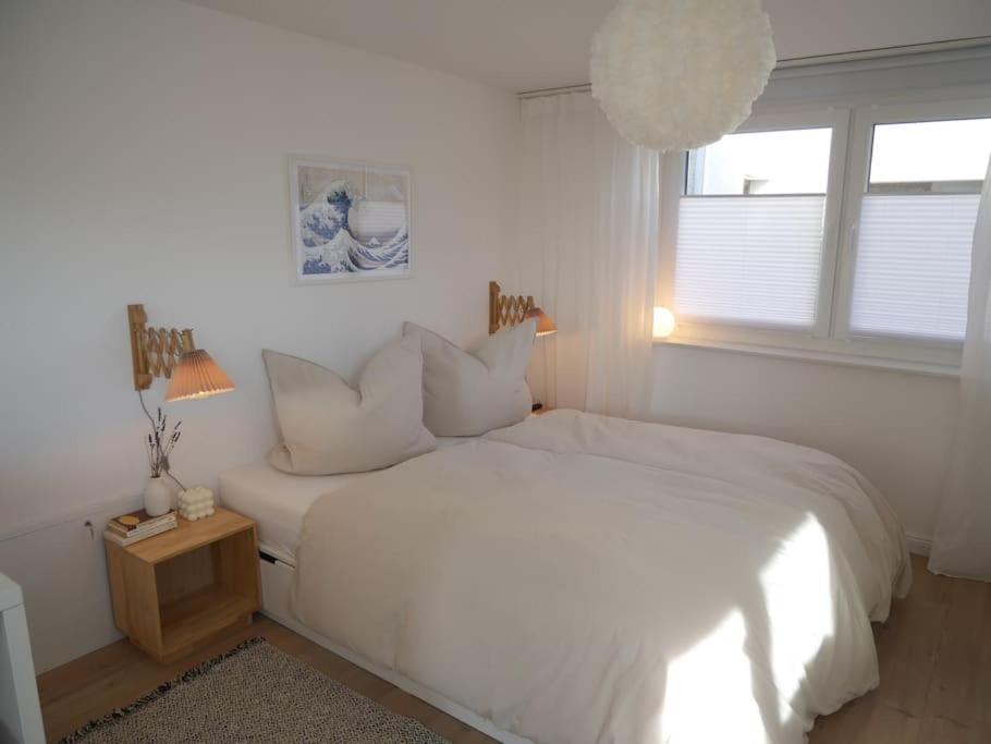 a white bedroom with a white bed and a window at Moderne Studio Ferienwohnung in Bad Doberan in Bad Doberan