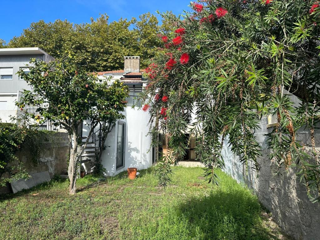 Porto Foz Beach في بورتو: منزل أبيض مع زهور حمراء على الحائط