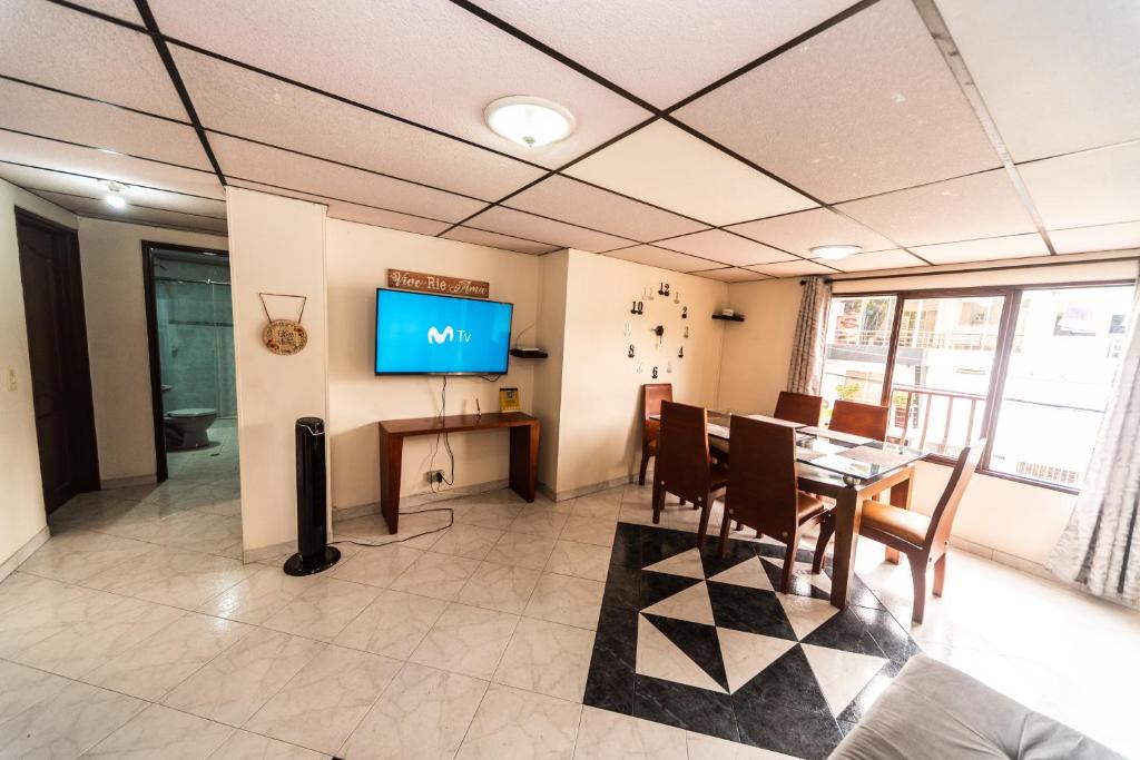 ein Esszimmer mit Tisch und Fernseher in der Unterkunft Lindo apto al lado del parque del ingenio in Cali