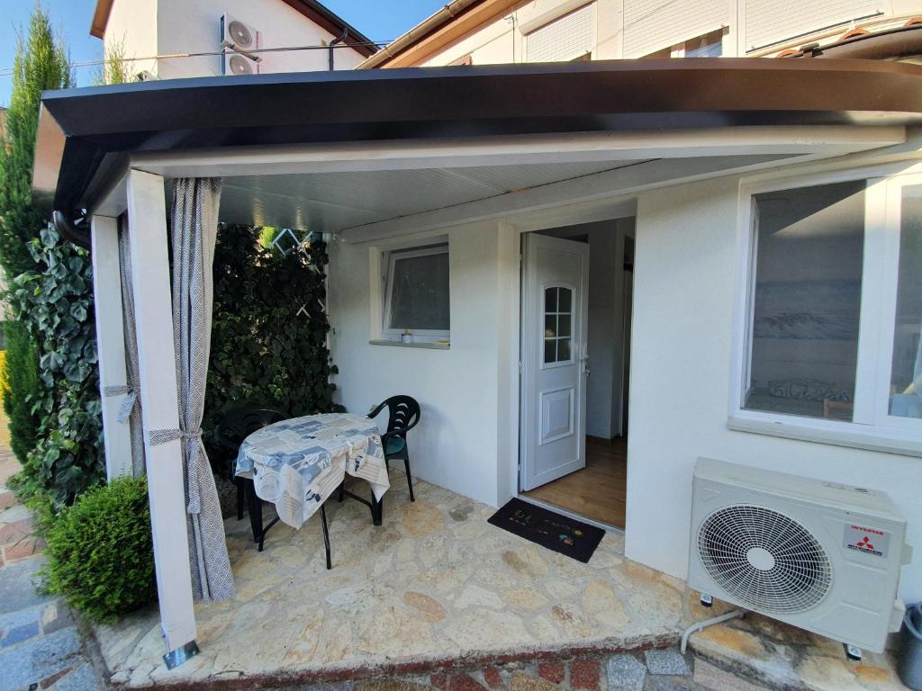 an open patio with a table and a fan at Una in Umag