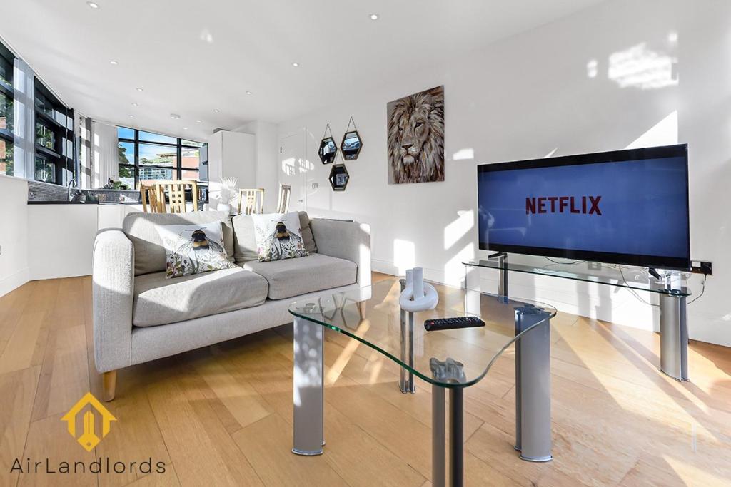 sala de estar con sofá y TV en Exclusive 2 Bedroom Flat near Buckingham Palace, en Londres