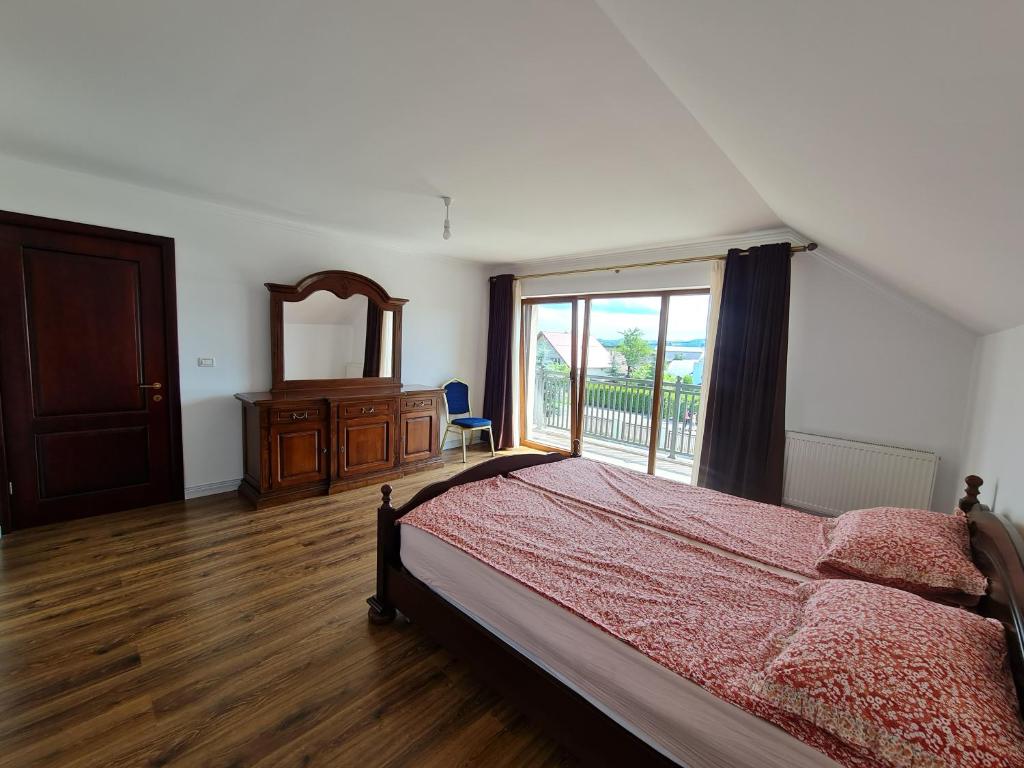 - une chambre avec un lit, une commode et une fenêtre dans l'établissement Casa Elisabeta, à Bilca