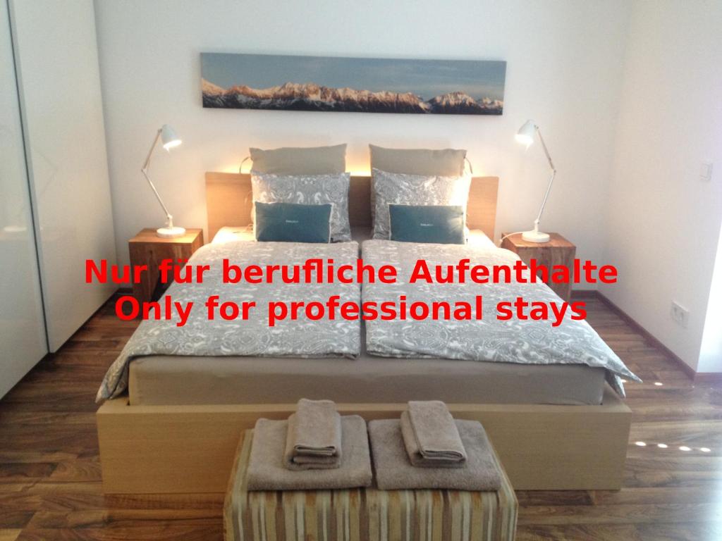 een slaapkamer met een bed met twee lampen erop bij Sunny Apartment in Innsbruck