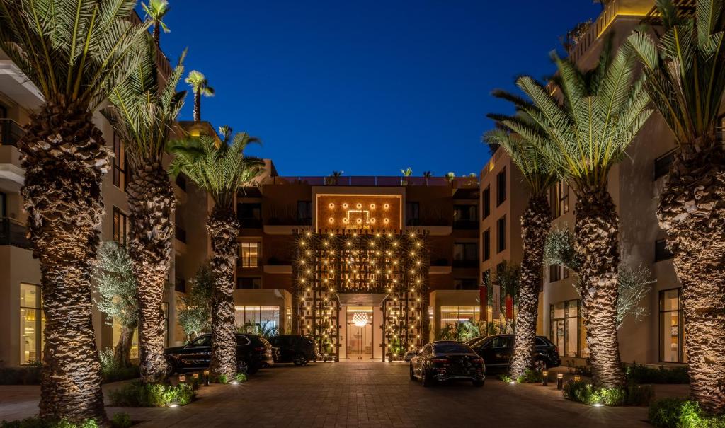 un hotel con palmeras frente a un edificio en Pestana CR7 Marrakech, en Marrakech