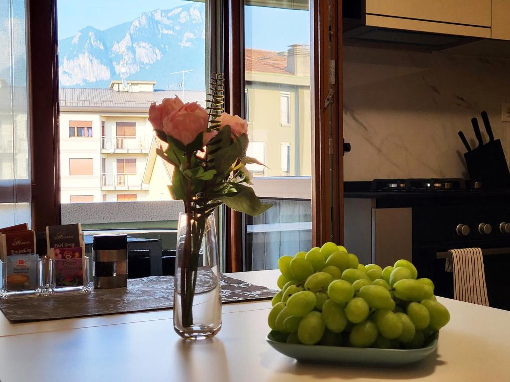 a vase with flowers and a bowl of fruit on a table at Casa Lariana in Lecco