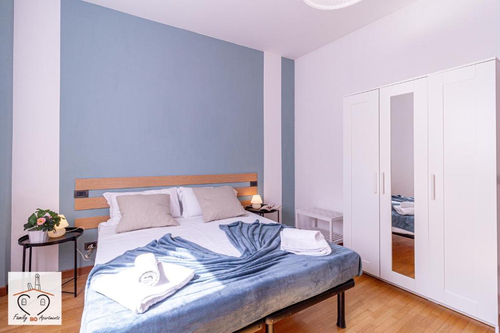 a bedroom with a bed with a blue blanket on it at FamilyBO Apartments Sant'Orsola in Bologna