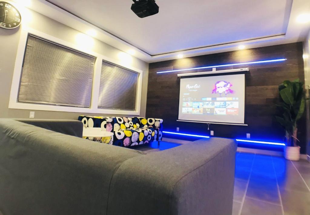 uma sala de estar com um sofá e um ecrã de projecção em Modern, Cheerful 2BD 1BR Apt+Free parking em Halifax