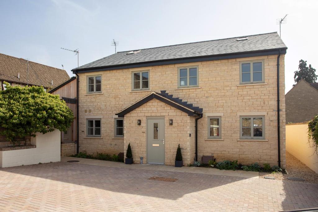 a large brick house with a grey door at Harpers Yard - 30 Chipping Norton in Chipping Norton