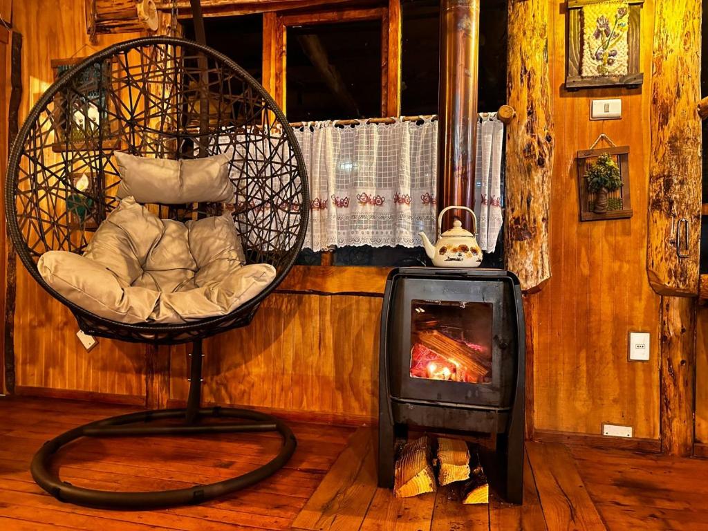 Pokój z krzesłem i piecem opalanym drewnem w obiekcie Ruta 7 Coffee & Lodging w mieście Villa Maniguales