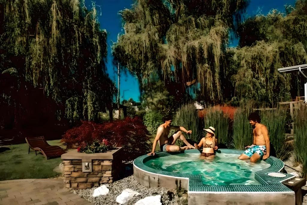 a group of people sitting in a swimming pool at Serene Waterfront Escape with Pool, Hot Tub, Pet-Friendly Haven, & Breathtaking Views in Kelowna