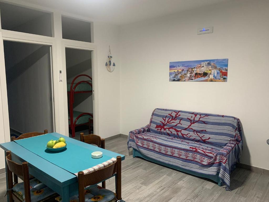 ein Wohnzimmer mit einem blauen Tisch und einem Sofa in der Unterkunft La coccinella rooms in Milazzo