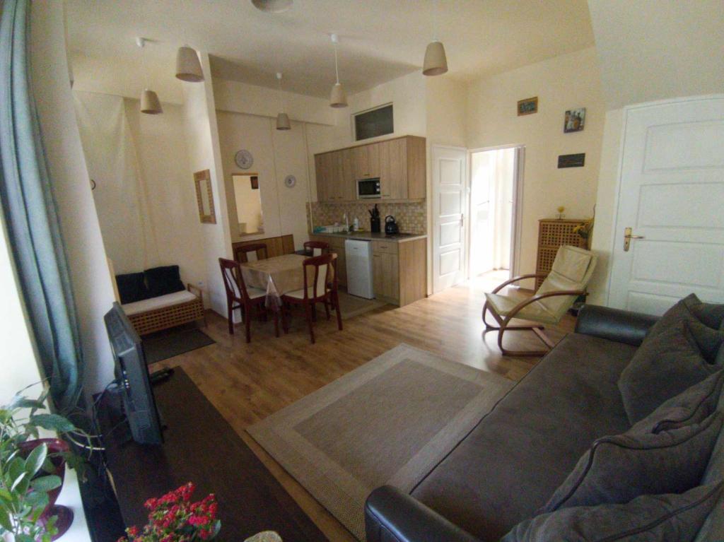 エゲルにあるCéhmesterek apartmanのリビングルーム(ソファ、テーブル付)、キッチンが備わります。