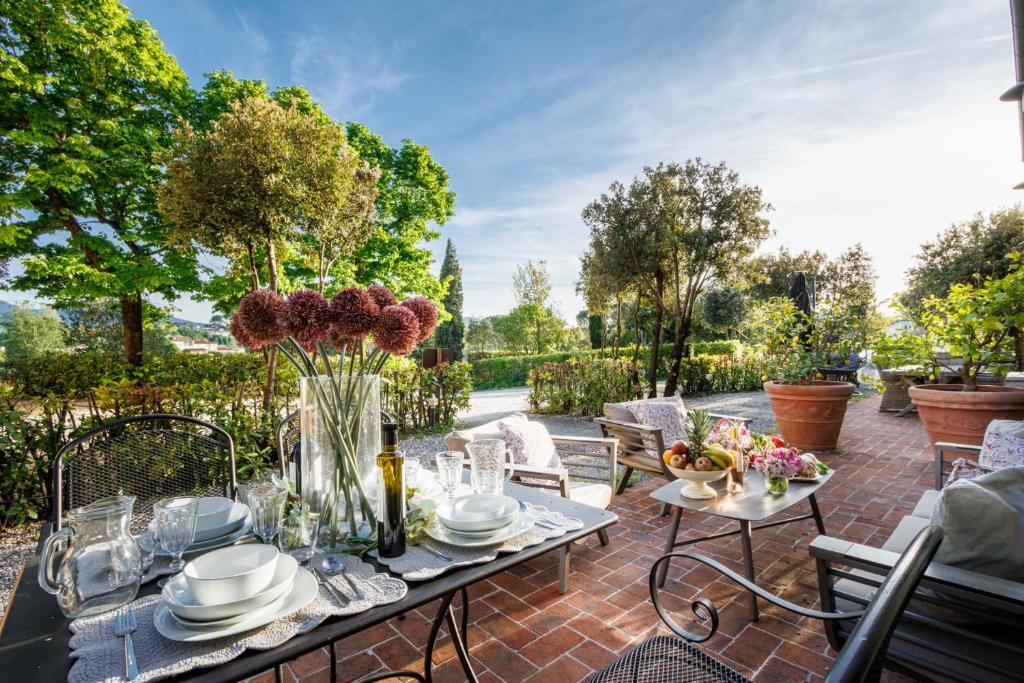 patio con tavolo e fiori di Jacopo Farmhouse Apartment in Wine Resort in Lucca a Lucca