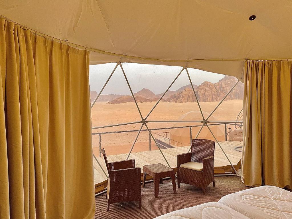 ein Schlafzimmer mit Blick auf die Wüste von einem Zelt aus in der Unterkunft Daniela Camp Wadi Rum in Wadi Rum