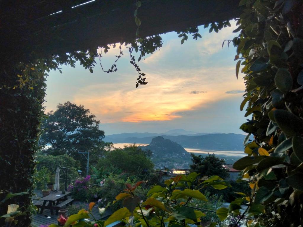 a view of the sunset from a house window at Habitación con vista al lago in Valle de Bravo