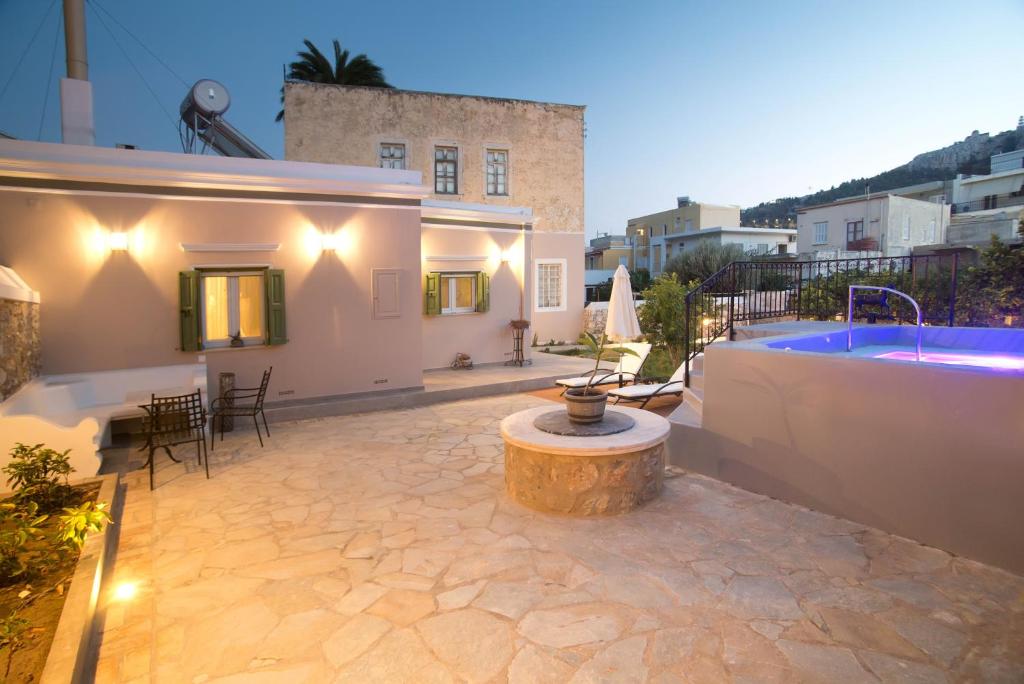 een patio met een bad en een tafel en een gebouw bij Grandma's House in Kalymnos