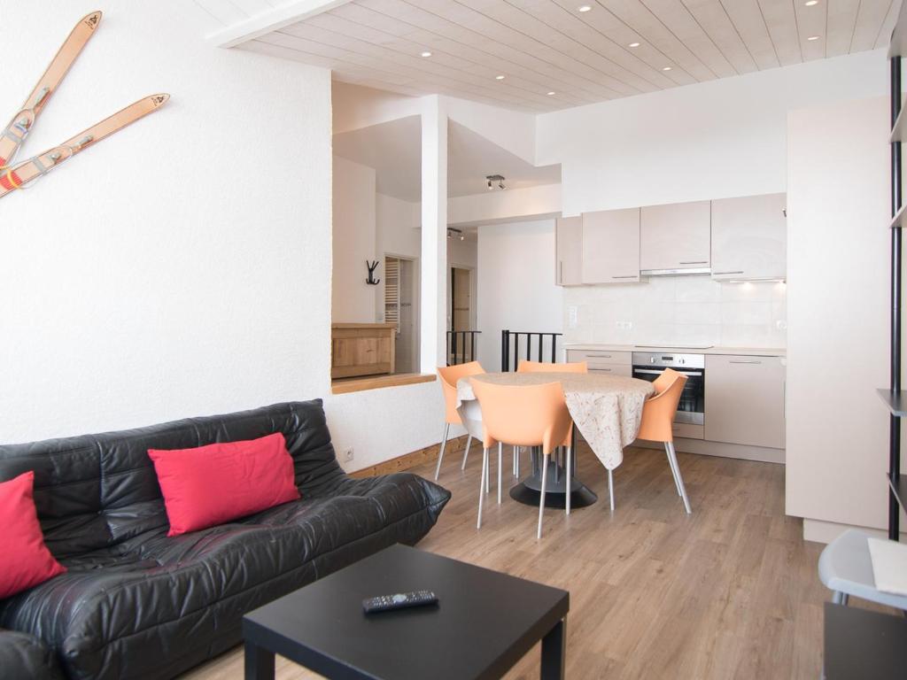 un salon avec un canapé en cuir noir et une table dans l'établissement Duplex 3 pièces au pied des pistes avec WiFi à Tignes - FR-1-449-70, à Tignes