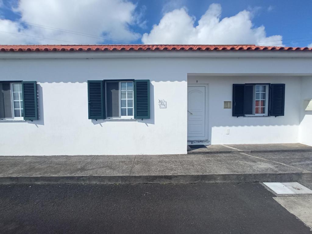 a white house with blue shutters on it at OCEANVIEW in Lajes das Flores