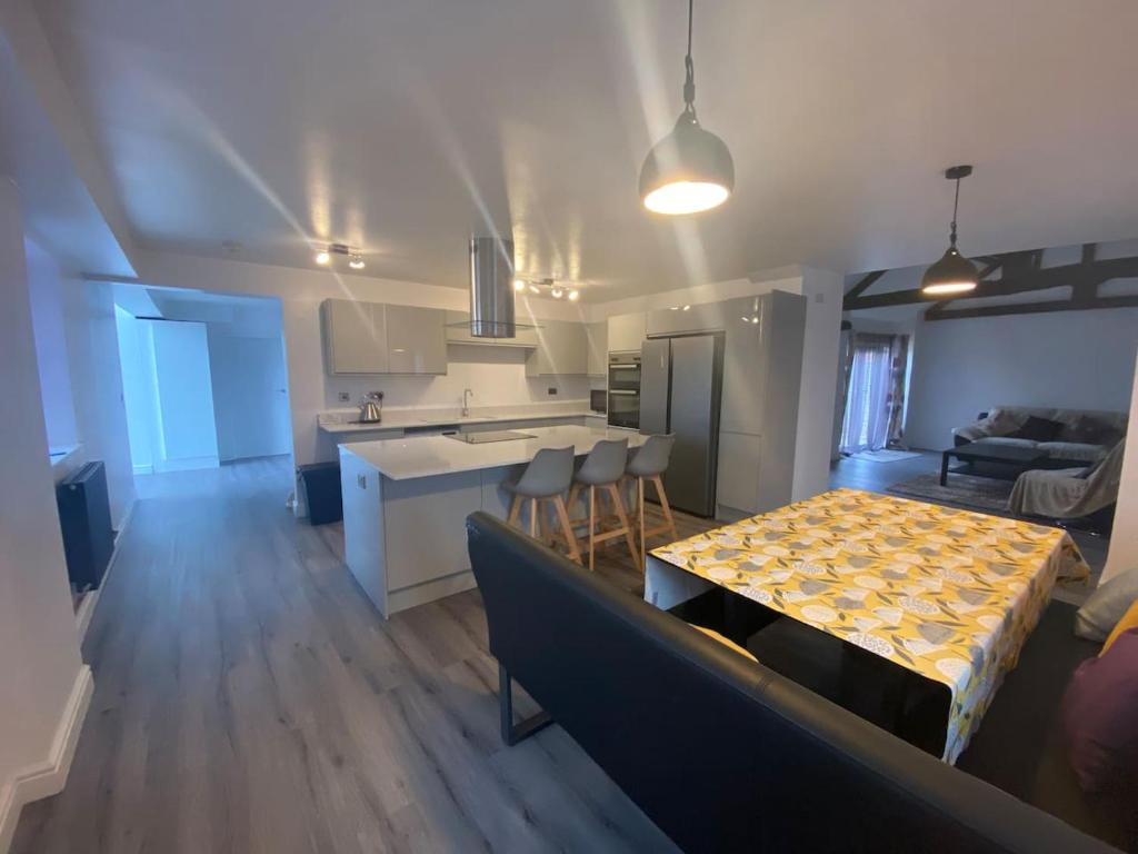 a kitchen and a living room with a table and chairs at Spacious 4 bedroom, 4 bathroom barn conversion home with private garden and free parking in Burn