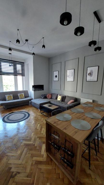 a living room with a table and a couch at Bonjour Apartment bezpłatny parking in Łódź