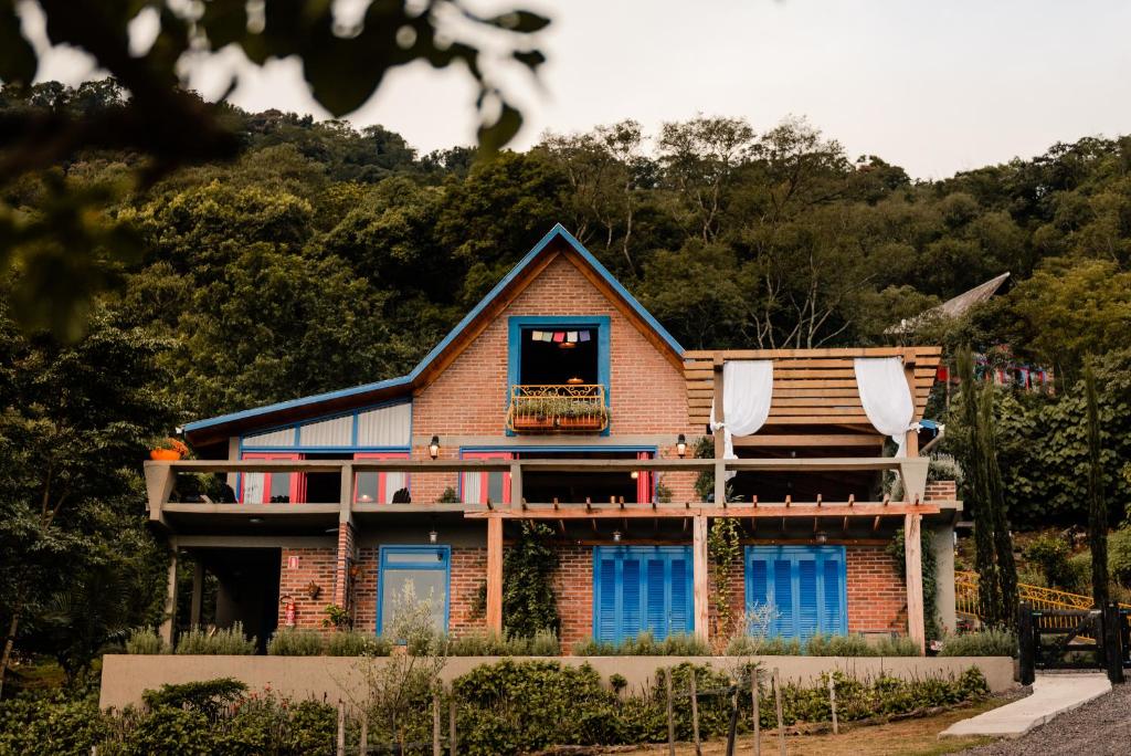 a brick house with a balcony and a porch at Pousada Morada Dos Anjos in Arroio do Meio