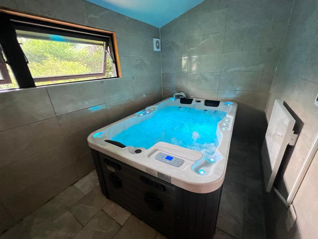 una grande vasca in un bagno con finestra di Spacieux chalet à Aywaille ad Aywaille