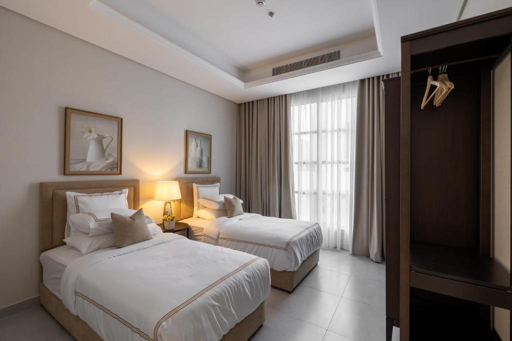 a hotel room with two beds and a flat screen tv at شقة فندقية رائعة - موقع مميز حطين الرياض in Riyadh